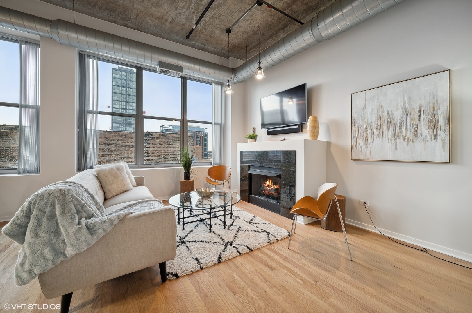 933 West Van Buren Street, Unit 917 Chicago, IL 60607 - Photo 3 of 24 a living room with furniture fireplace and a flat screen tv