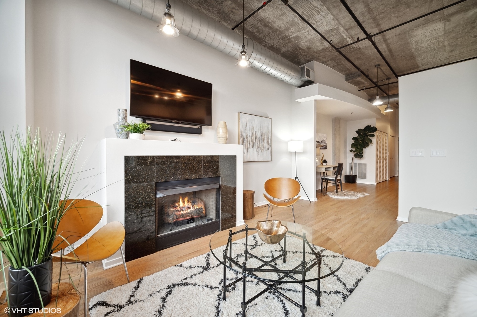 933 West Van Buren Street, Unit 917 Chicago, IL 60607 - Photo 5 of 24 a living room with furniture a flat screen tv and a fireplace