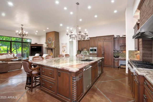 a kitchen with kitchen island granite countertop a sink counter and chairs