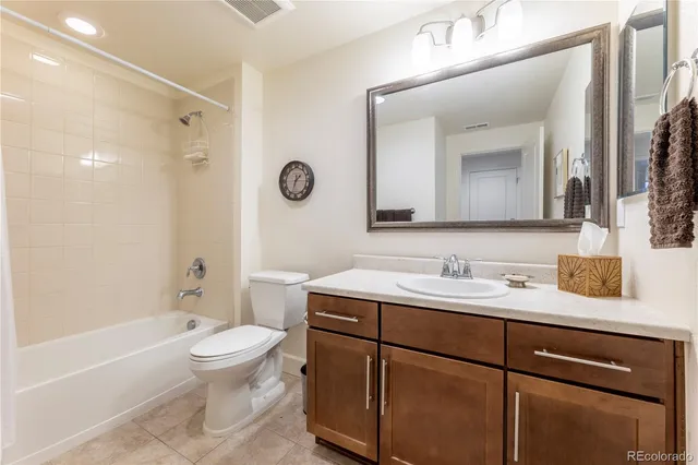a bathroom with a granite countertop sink toilet a mirror and shower