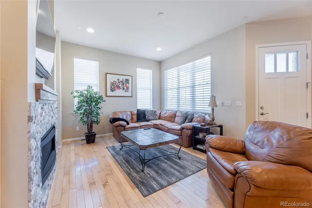 a living room with fireplace furniture and a wooden floor