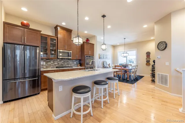a kitchen with a dining table chairs sink and wooden floor
