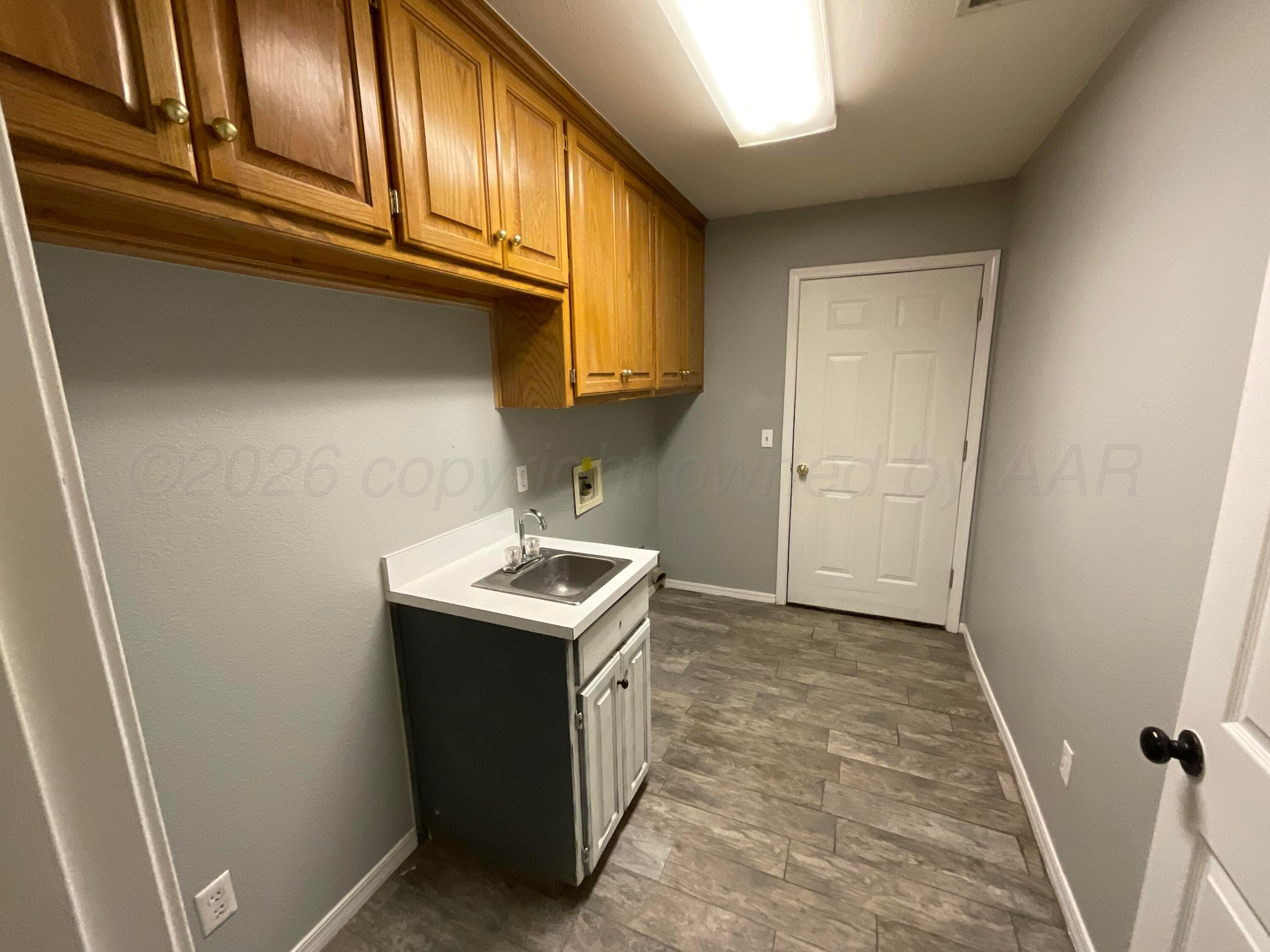 8101 Sheldon Road Amarillo, TX 79119 - Photo 17 of 20 a utility room with a sink a refrigerator and window