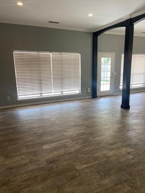 8101 Sheldon Road Amarillo, TX 79119 - Photo 4 of 20 an empty room with wooden floor and windows