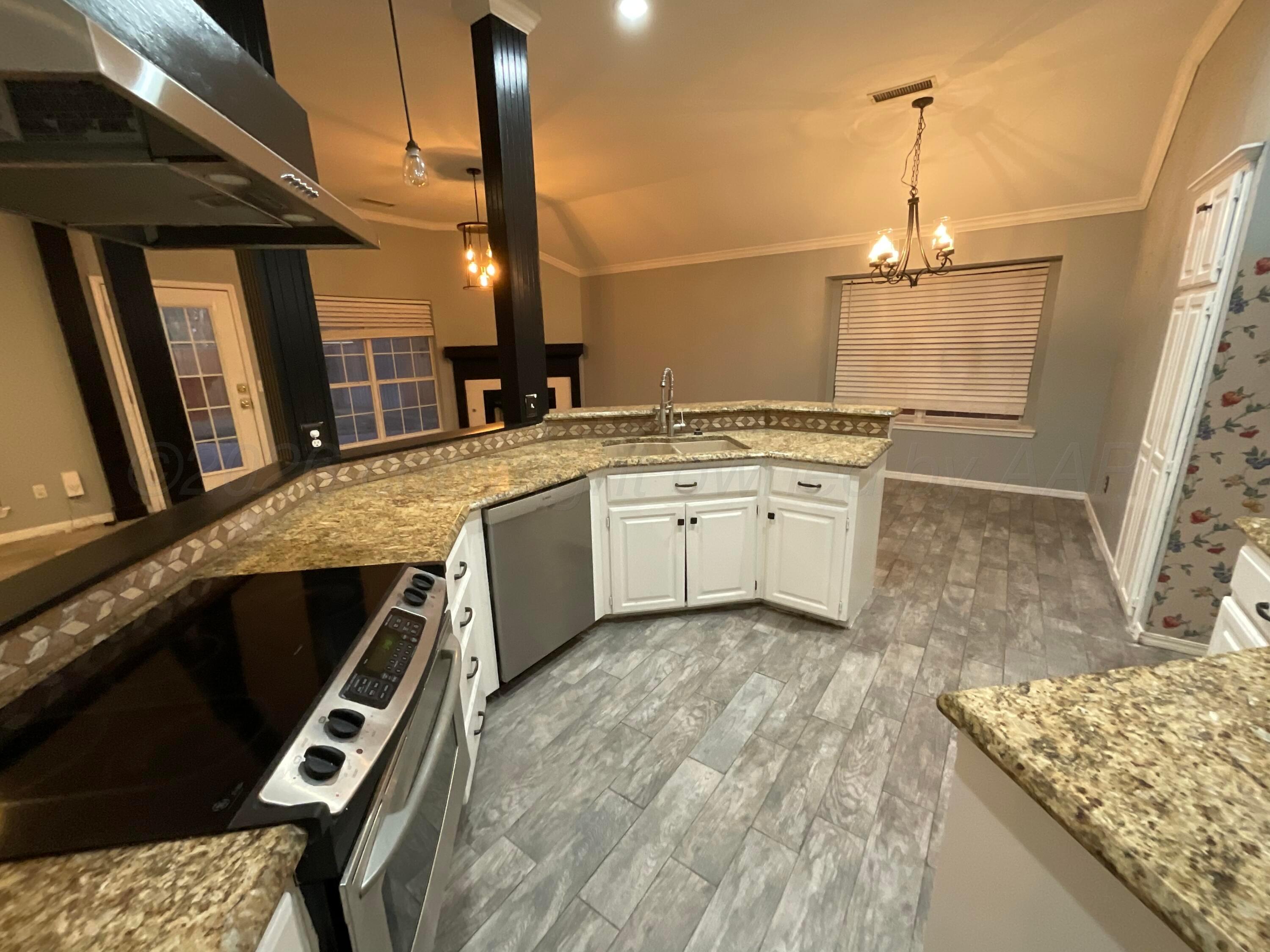 8101 Sheldon Road Amarillo, TX 79119 - Photo 5 of 20 a kitchen with a stove a sink and a refrigerator