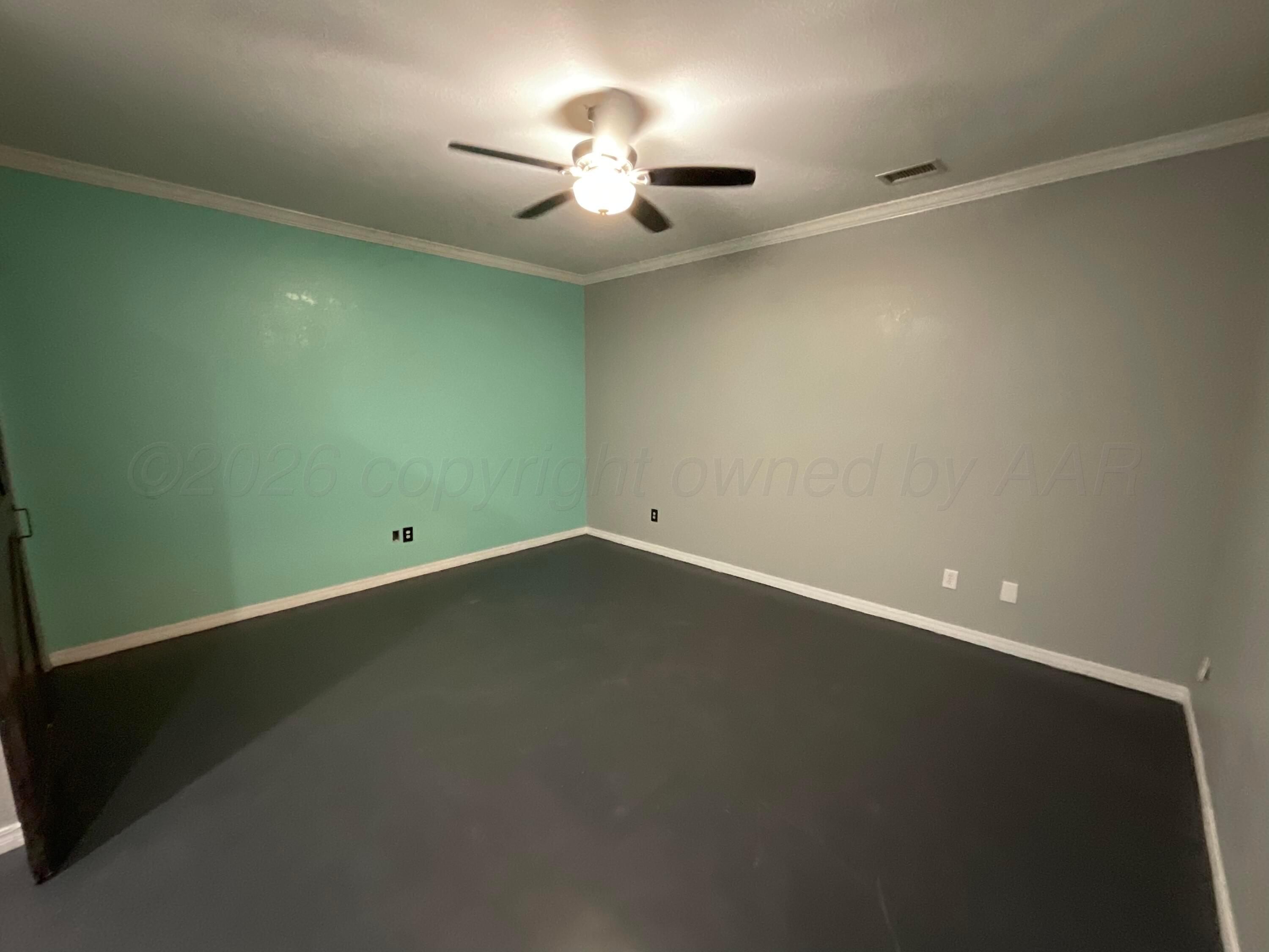 8101 Sheldon Road Amarillo, TX 79119 - Photo 9 of 20 an empty room with a ceiling fan and a window