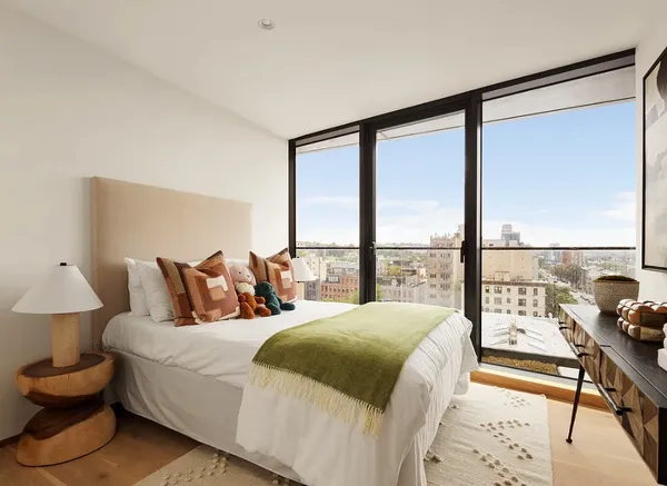 a bedroom with a bed and a large window with outer view