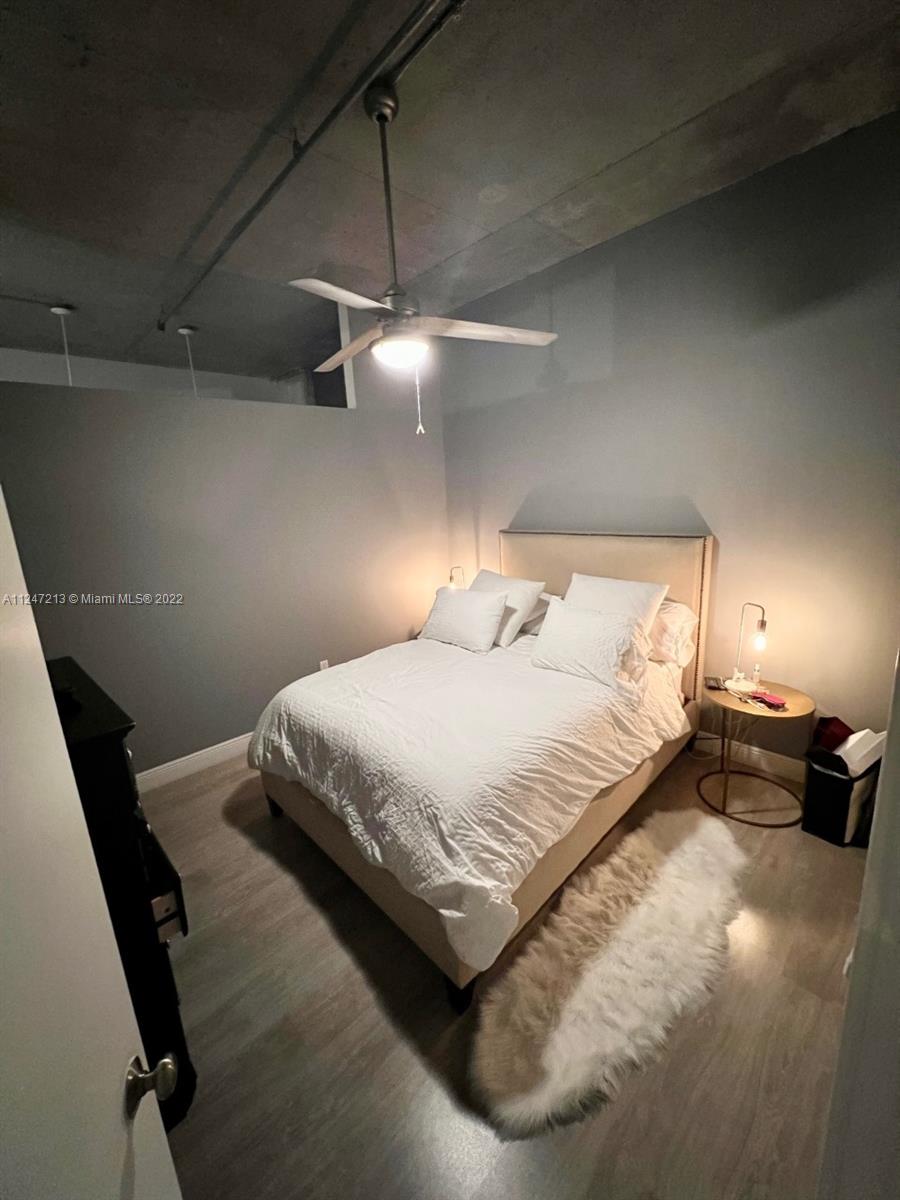 2001 Biscayne Boulevard, Unit 2414 Miami, FL 33137 - Photo 7 of 8 a bedroom with a bed and a chandelier