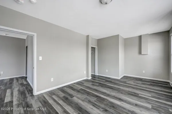 a view of a room with wooden floor and window