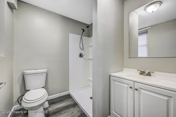 a bathroom with a sink a toilet and shower
