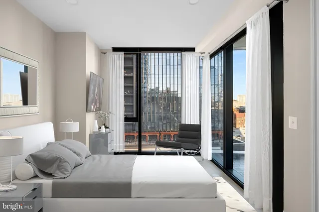 a bedroom with a bed and large windows