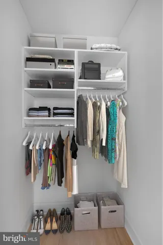 a view of walk in closet with clothes and shoes