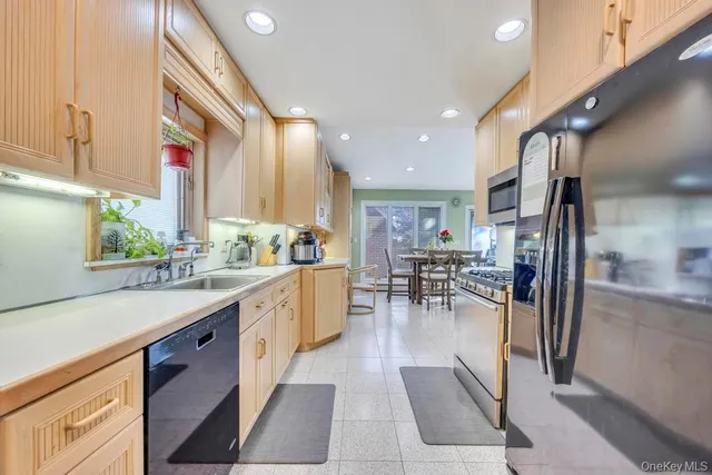 a large kitchen with stainless steel appliances lots of counter space and a sink