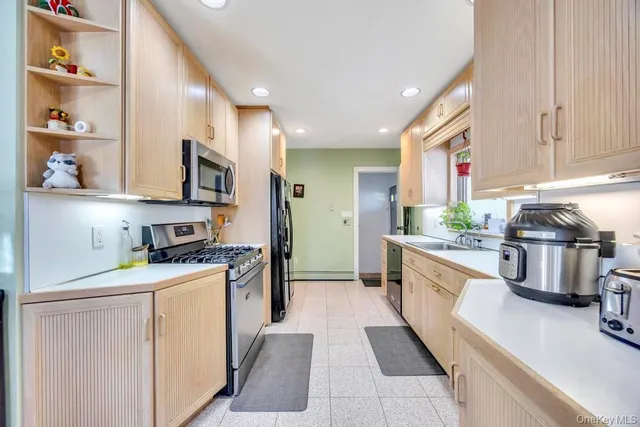 a kitchen with stainless steel appliances granite countertop a stove a sink and a refrigerator