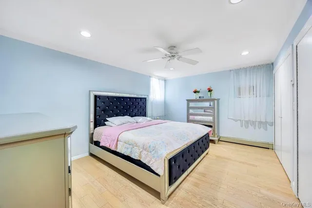 a bedroom with a large bed a chandelier and dresser