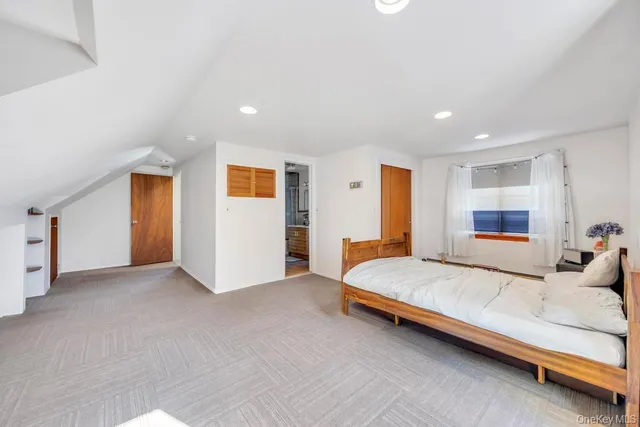 a spacious bedroom with a bed and a large window