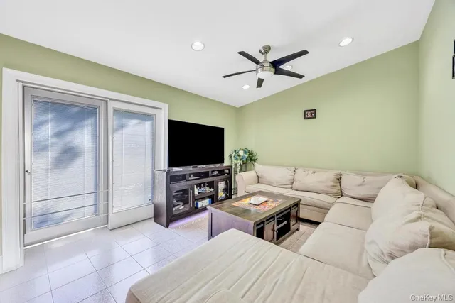 a living room with couches a flat screen tv and kitchen view