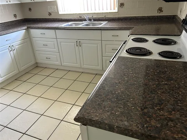 a kitchen with a sink stove and cabinets