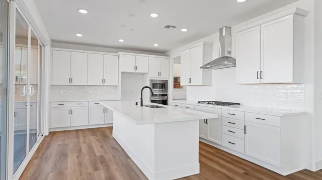 a kitchen with white cabinets and stainless steel appliances