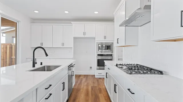 a kitchen with white cabinets and appliances