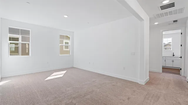 an empty room with windows and bathroom