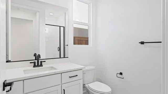 a bathroom with a sink a toilet and mirror