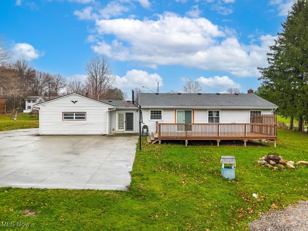 Back of house with a yard and a wooden deck