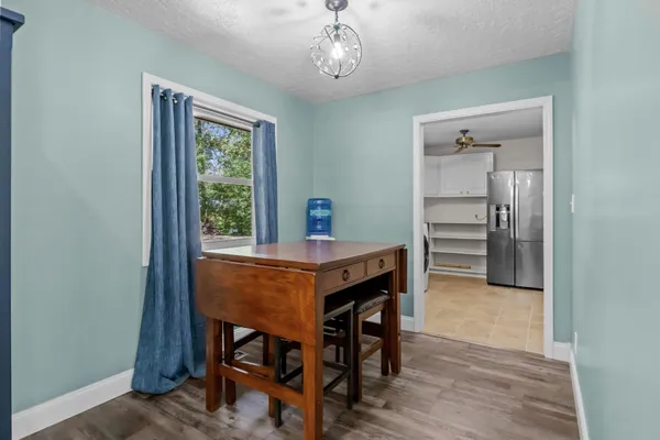 a kitchen that has a table chairs in it and wooden floors