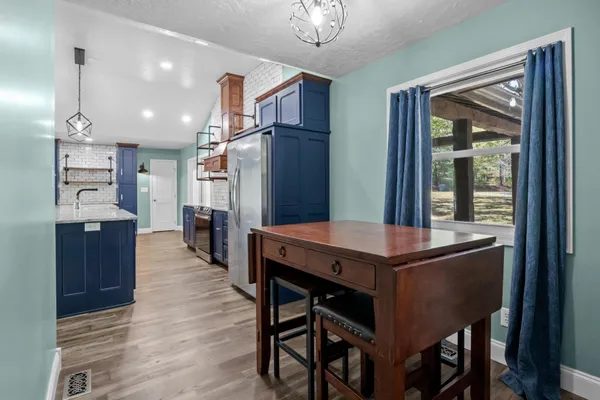 a view of a kitchen with refrigerator and cabinets