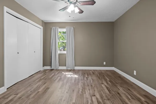 a view of a room with a ceiling fan and a window