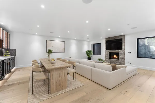 a living room with furniture a flat screen tv and kitchen view