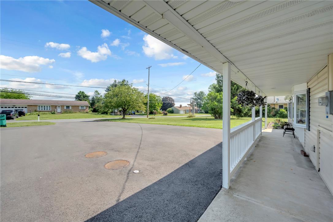439 Cherry Hill Road Nazareth, PA 18064 - Photo 27 of 31 A welcoming covered porch with a railing overlooks the asphalt driveway and verdant lawn.