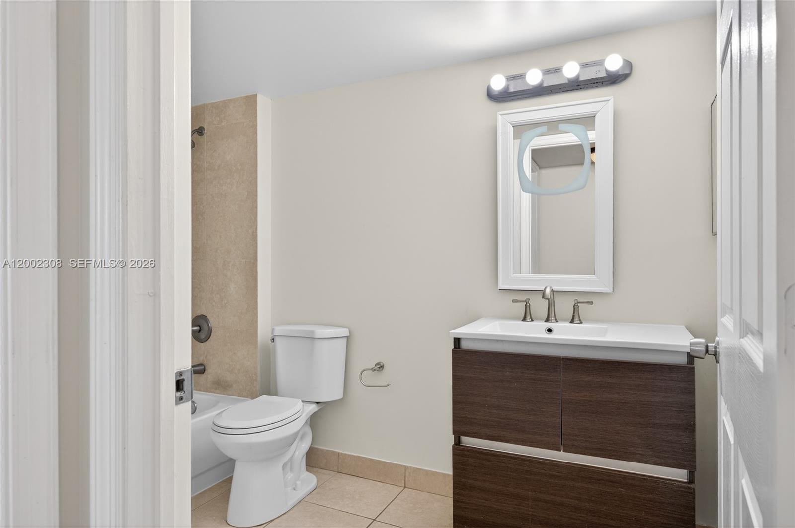4025 West McNab Road, Unit E109 Pompano Beach, FL 33069 - Photo 15 of 27 a bathroom with a toilet sink and mirror