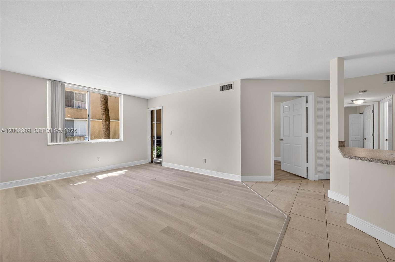 4025 West McNab Road, Unit E109 Pompano Beach, FL 33069 - Photo 2 of 27 a view of an empty room with window and wooden floor