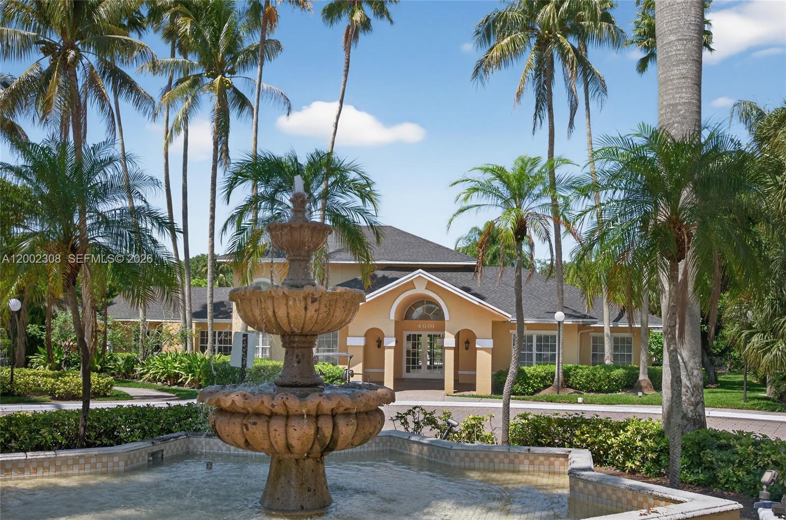 4025 West McNab Road, Unit E109 Pompano Beach, FL 33069 - Photo 24 of 27 a front view of a house with fountain and garden