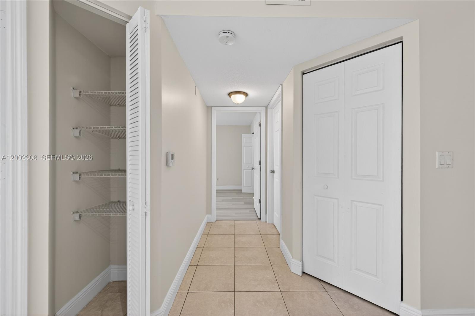 4025 West McNab Road, Unit E109 Pompano Beach, FL 33069 - Photo 9 of 27 a view of a hallway with wooden floor and a bathroom