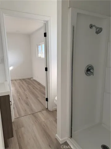 a view of empty room with wooden floor and window