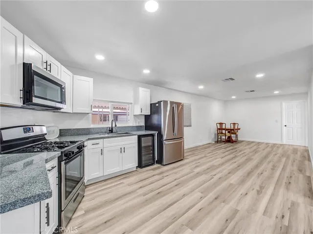 a kitchen with stainless steel appliances granite countertop a refrigerator stove microwave and sink