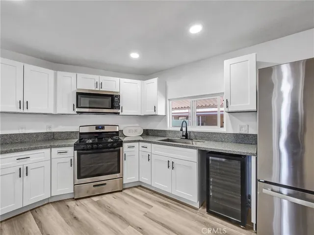 a kitchen with stainless steel appliances granite countertop a stove a sink and a refrigerator