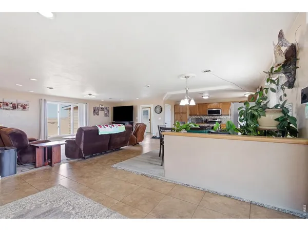 a living room with furniture a flat screen tv and a large window