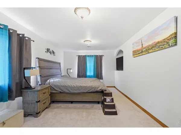 a bedroom with a bed and a flat tv screen on the dresser