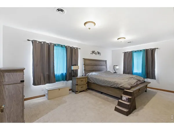 a bedroom with a bed window and dresser