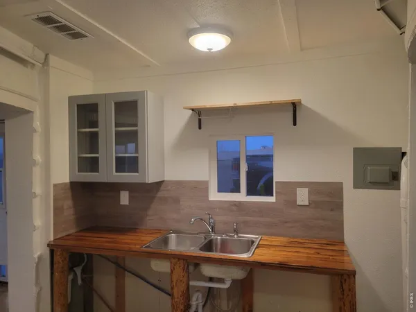 a kitchen with a sink cabinets and wooden floor