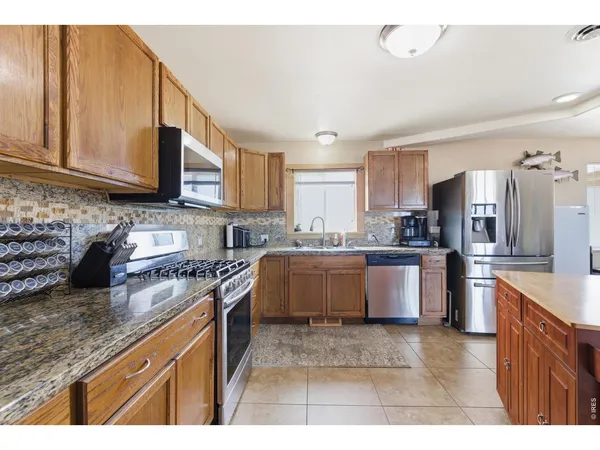 a kitchen with stainless steel appliances granite countertop a stove a sink dishwasher a refrigerator and a oven
