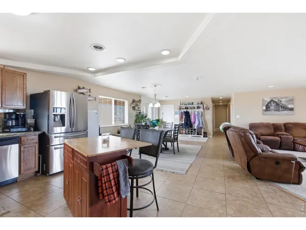 a living room with furniture a table and kitchen view