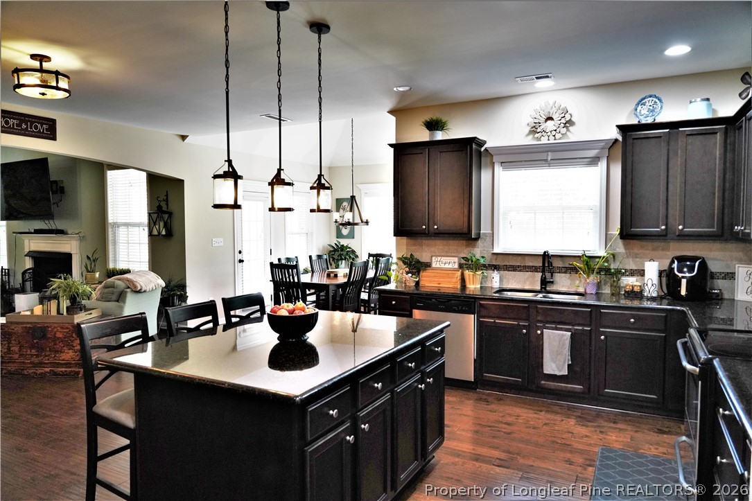 930 Old Vander Road Fayetteville, NC 28312 - Photo 15 of 45 a kitchen with stainless steel appliances a sink a stove and chairs