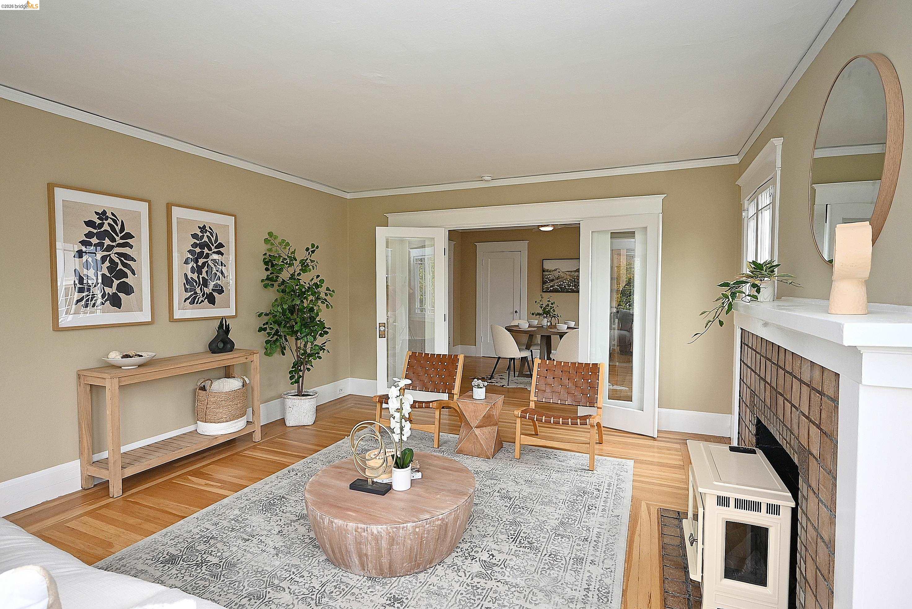 1301 Bonita Avenue, Unit 3 Berkeley, CA 94709 - Photo 14 of 48 Living area featuring wood-finish flooring, a fireplace with a tiled surround and white mantel, and crown molding