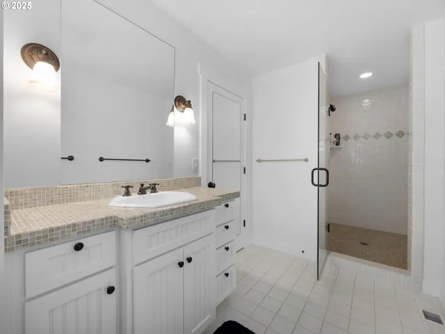 a bathroom with a granite countertop sink mirror and shower