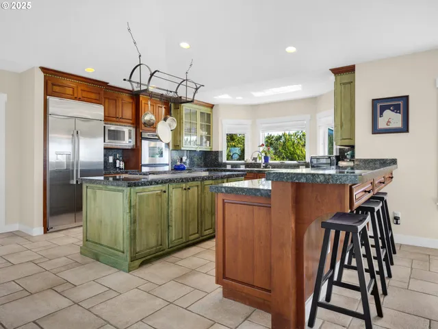 a kitchen with green cabinets a sink and stainless steel appliances