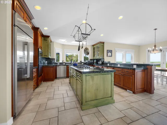 a kitchen with stainless steel appliances granite countertop a refrigerator a sink a stove top oven and cabinets